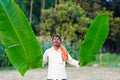 Indian farmer holding leaf of banana in his hand