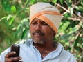 An indian farmer looking on mobile phone screen at agricultural field at latur maharashtra