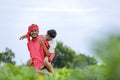 Indian farmer playing with his child at green field