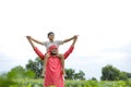 Indian farmer playing with his child at green field