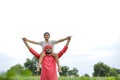 Indian farmer playing with his child at green field