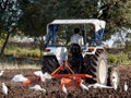 Indian farmer with tractor preparing land for sowing with cultivator, an indian farming scene