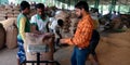 Indian village farmers measuring weight of wheat sack at wholesale godown