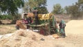 Indian farmers separating husk and wheat grain by use of thresher machine Royalty Free Stock Photo