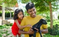 Indian father and daughter playing with a little goat in the garden Royalty Free Stock Photo