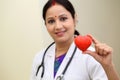 Indian female doctor holding a beautiful red heart shape Royalty Free Stock Photo