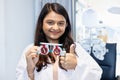 Indian female doctor optometrist showing messbrille eye test glasses. Eyesight modern ophthalmology in clinic. measurement check