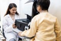 Indian female doctor optometrist using ophthalmology equipment scan checkup iris examines for patient kid male in clinic Royalty Free Stock Photo