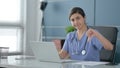 Indian Female Doctor Showing Thumbs Down Sign While using Laptop in Office Royalty Free Stock Photo