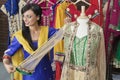 Indian female dressmaker measuring traditional outfit at design studio
