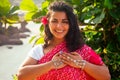 Indian female fashion model white-toothed smile with flower in her curly hair in traditional india outfit red wedding Royalty Free Stock Photo