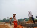 an indian female labour transporting building materials on head during construction in india dec 2019