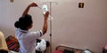 an indian female nurse staff injecting needle into the bottle during treatment in india aug 2019