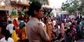 indian female police officer on duty between traditional public at temple in India