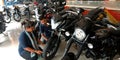 indian female staff looking at bike wheel latest technology at Bajaj bike showroom in India