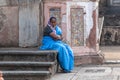 An Indian female worker wearing a blue sari guarding an ancient heritage site in Old Goa