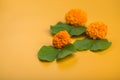 Indian Festival Dussehra, showing golden leaf Bauhinia racemosa and marigold flowers on a yellow background