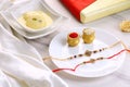 Indian Festival Raksha Bandhan with Rakhi, Sweets, Rice Grains