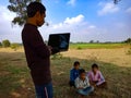 indian poor villager giving training about laptop computer system at green field in india January 2020 Royalty Free Stock Photo