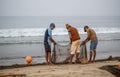 Indian fishermen sorting freshly catch fish from fishing net at Malvan beach at morning