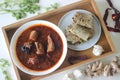 Indian flat bread made of whole wheat flour with grounded flax seed and fresh coriander leaves served with red gravy fish curry Royalty Free Stock Photo