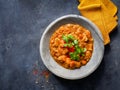 Indian food recipe. Chicken tikka masala spicy curry meat food in marble plate with spices and parsley on dark textured background Royalty Free Stock Photo