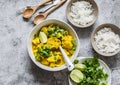 Indian food table - vegetarian cauliflower curry sauce, rice, cilantro, lime on grey background, top view