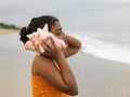 Indian girl listening to a conch