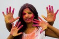 Indian girl showing her colourful hands printing or playing holi festival with colours, isolated white background.Young girl plays