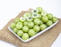 Indian gooseberry fruits or Amla berry phyllanthus emblica and sliced in white palte on white background