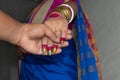 An Indian groom holding the hand of the bride for the wedding promise. Selective focus on the wedding ring and fingers. Concept of