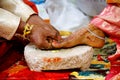 Indian groom placing toe ring to the brides leg