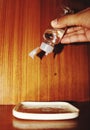 An Indian hand dropping water from the bottle on a white plate placed on a wooden table Royalty Free Stock Photo