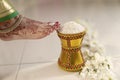 Indian Hindu Bride entering groom's home after wedding by pushing pot filled with rice with her foot. Royalty Free Stock Photo