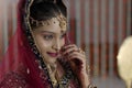 Indian Hindu Bride with jewelry looking in mirror.