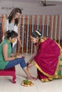 Indian Hindu Bride with turmeric paste on face with sister and mother.