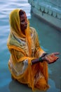 Indian Hindu woman devotee offering prayers to the Sun God during Chhath Puja in Varanasi, Uttar Pradesh, India