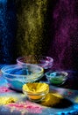 Indian Holi festival colours. Several bowls with Holi paint powder. Explosion of purple, yellow and blue color. Royalty Free Stock Photo