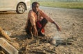 Indian homeless man sits beside a fire to keep warm on a cold winter morning.