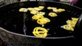 Indian jalebi frying in oil pan at stall