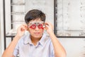 Indian kid boy with optometrist trial frame in ophthalmological clinic, Boy doing eye test checking examination with optometrist Royalty Free Stock Photo