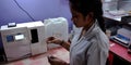 Indian lab technician girl checking samples at laboratory in india