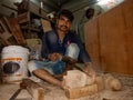 an indian labour chopping wood logs at art factory in India January 2020