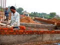 an indian labour holded brick during wall creation at home construction site in India dec 2019