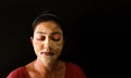 An indian lady with face pack applied in half dried condition with eyes closed front view