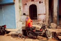 Indian lady sitting on motorbike on poor people area of old city Royalty Free Stock Photo