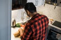 Indian or latino man cooking breakfast while standing at the kitchen at home, rear view Royalty Free Stock Photo