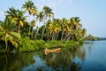 Indian local man in a canoe on river in along the kollam kottapuram waterway in the Kerala backwaters, India Royalty Free Stock Photo