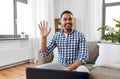 Indian male blogger waving hand at home