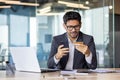 Indian male businessman working in office and trying to solve credit card problem, frowning at phone screen Royalty Free Stock Photo